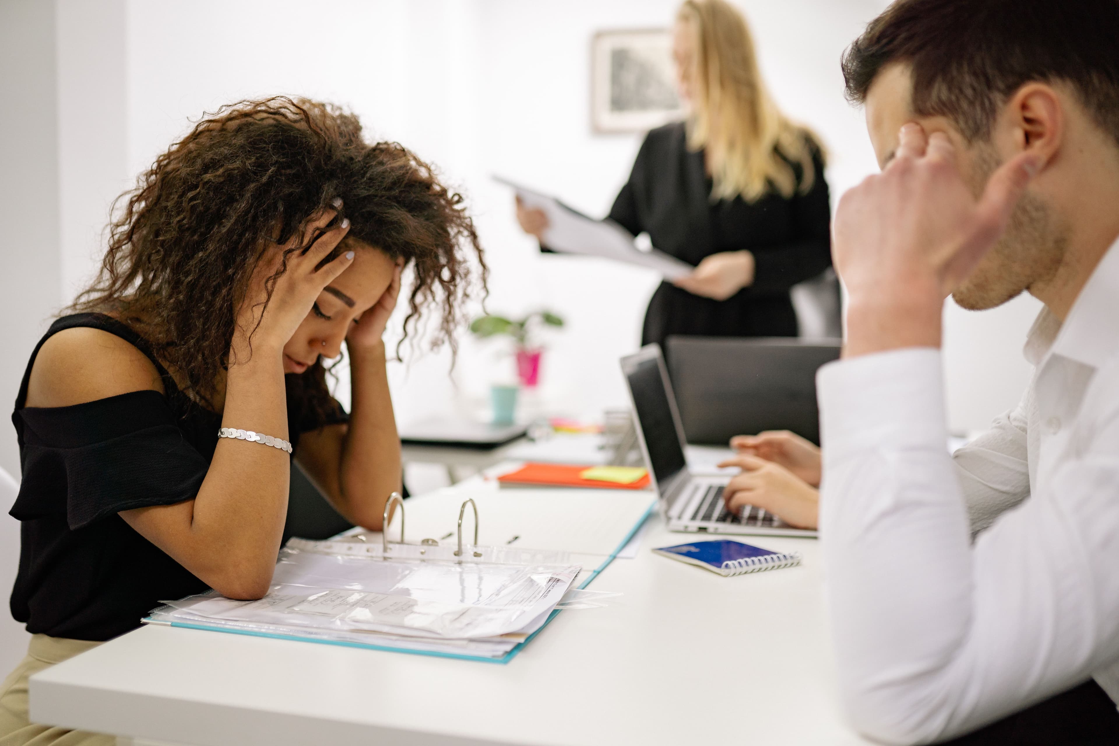 A stressed team buried in work, capable but stretched thin